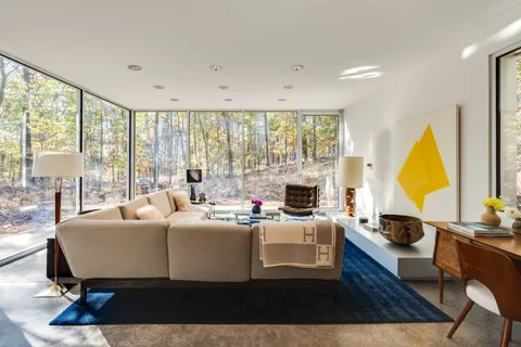 a living room with furniture a large window and a table