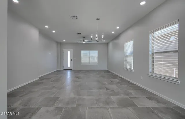 a view of an empty room with a ceiling fan and window