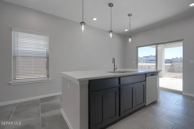 a kitchen with kitchen island a sink stainless steel appliances and counter space