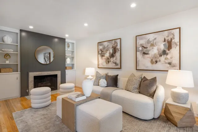 a living room with furniture a fireplace and wall paintings