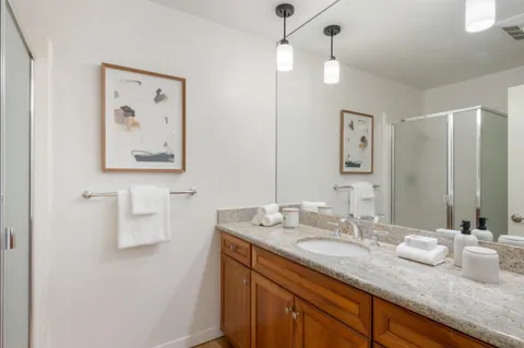 a bathroom with a granite countertop sink and a mirror