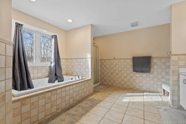 a bathroom with a bathtub and next to a window