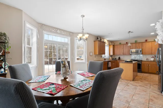 a dining room with furniture a chandelier and wooden floor