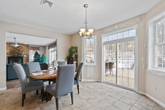 a dining room with furniture a chandelier and window