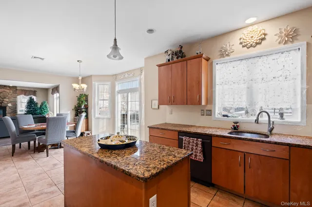 a kitchen with stainless steel appliances granite countertop a sink a counter space and a window