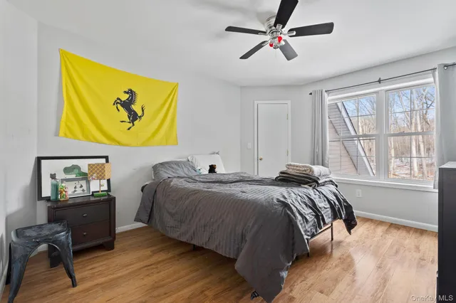 a bedroom with a bed dresser and wooden floor