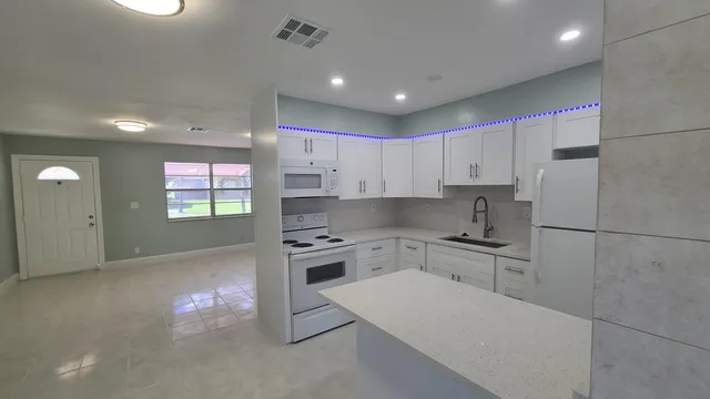a kitchen with granite countertop a sink stove and refrigerator