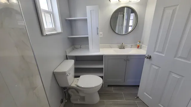 a bathroom with a toilet a sink and mirror