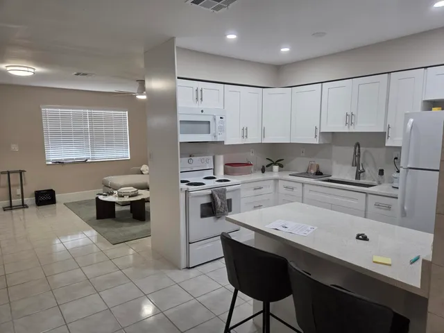 a kitchen with white cabinets and appliances