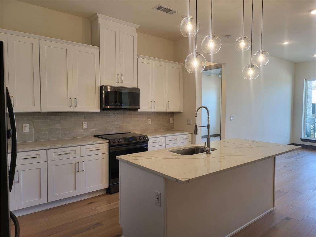 a kitchen with a sink cabinets and wooden floor