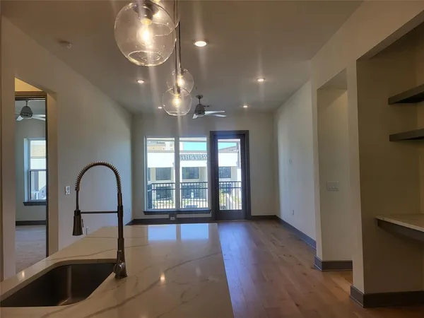 a view of a big room with wooden floor and windows