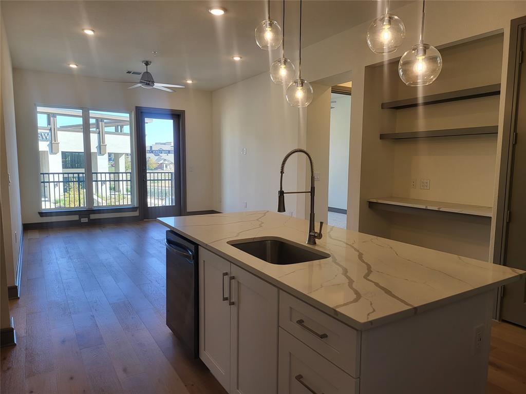 2700 Old Denton Road, Unit 2233 Carrollton, TX 75007 - Photo 4 of 13 a kitchen with a sink a counter space and a dining table