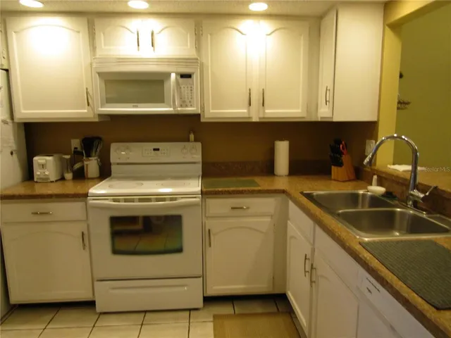 a kitchen with sink a microwave and cabinets