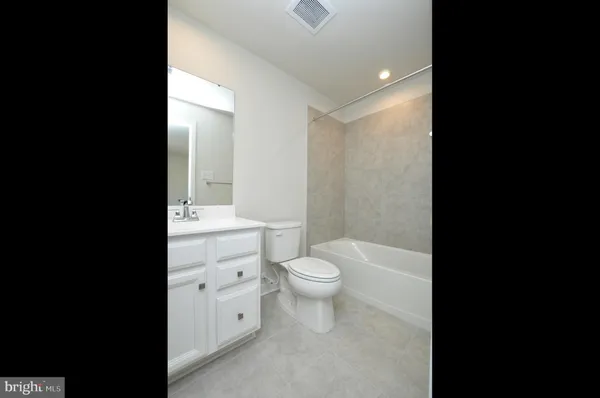 a bathroom with a toilet a sink and a large mirror