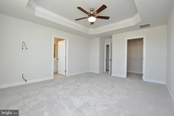 an empty room with closet and a ceiling fan