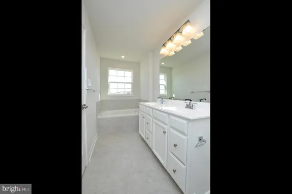 a bathroom with double vanity sink and mirror