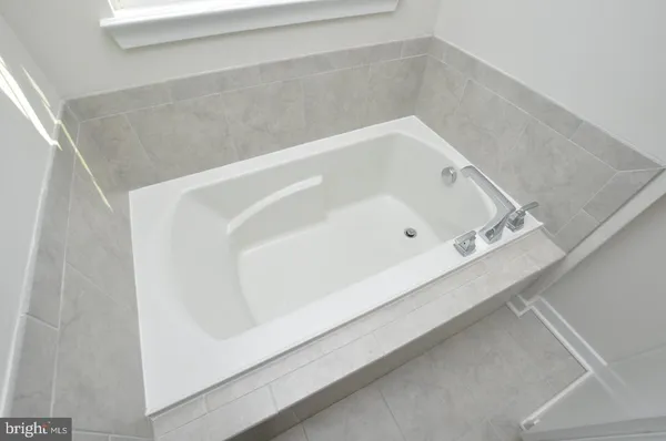 a bathroom with a white bath tub and shower