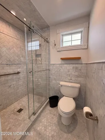 a bathroom with a toilet and a shower