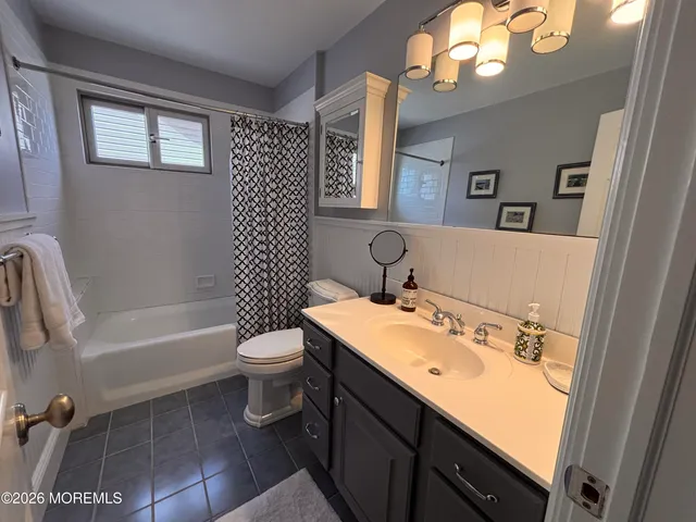 a bathroom with a sink a toilet a mirror and shower