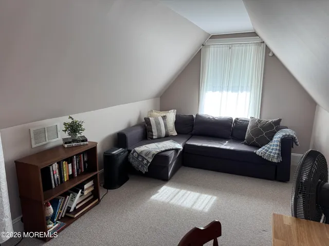 a living room with furniture and a book shelf