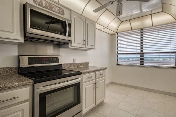 a kitchen with stainless steel appliances granite countertop a stove microwave and cabinets