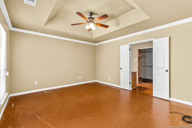 an empty room with closet and a ceiling fan