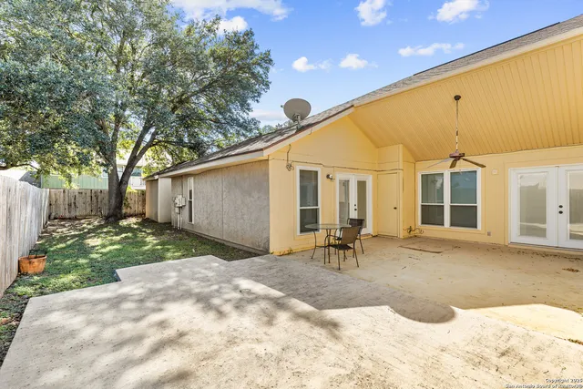 a backyard of a house with table and chairs