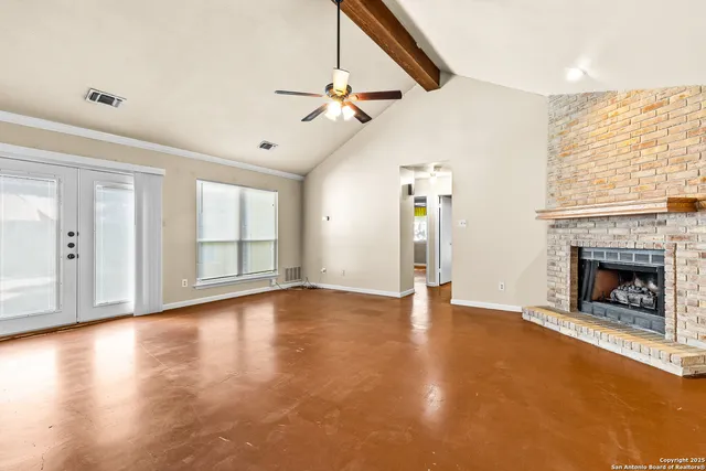 a view of an empty room with exposed radiator and fireplace