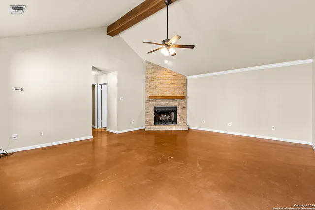 an empty room with windows and fireplace