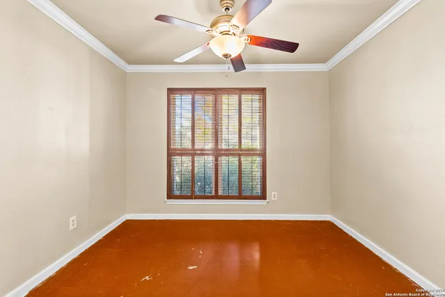 an empty room with window and ceiling fan