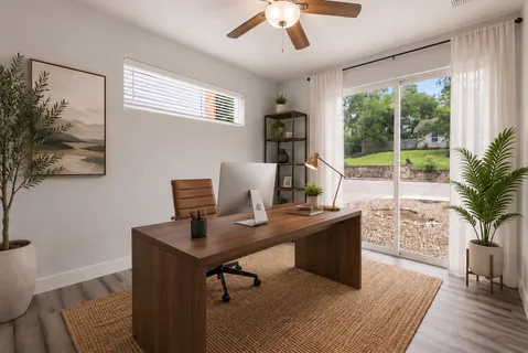 a view of a workspace with furniture and a window