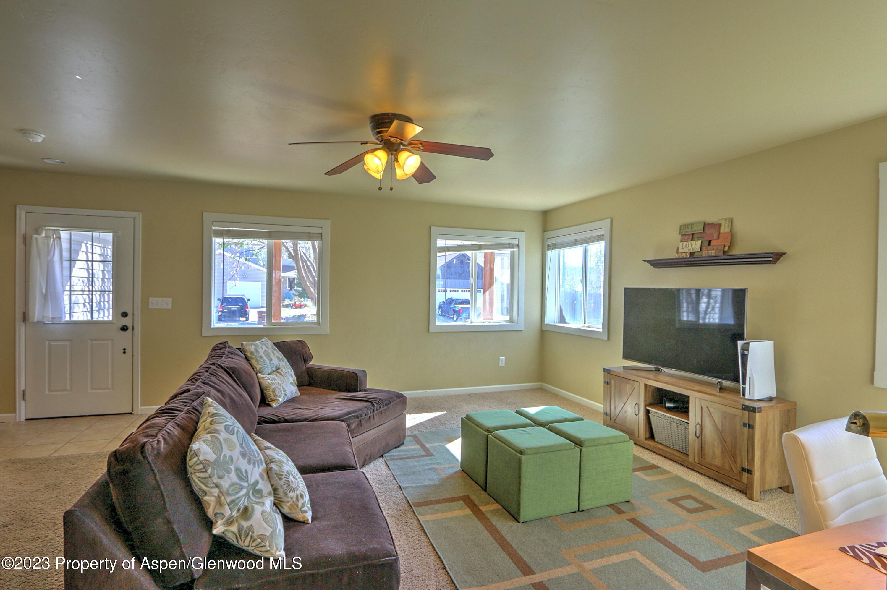 734 East 17th Street Rifle, CO 81650 - Photo 5 of 25 a living room with furniture a flat screen tv and a fireplace