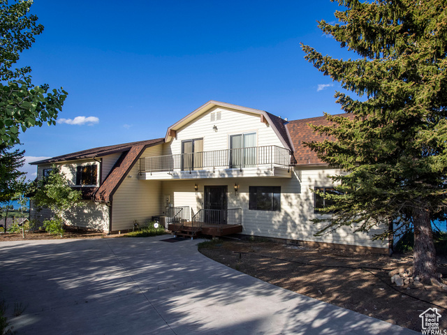 588 Raspberry Patch Road Garden City, UT 84028 - Photo 67 of 74 View of front facade featuring a gambrel roof, a shingled roof, and a balcony