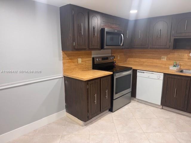 16300 Golf Club Road, Unit 208 Weston, FL 33326 - Photo 10 of 24 a kitchen with stainless steel appliances granite countertop a stove a sink and a refrigerator with wooden cabinets