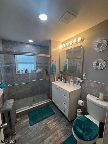 245 William Street Rahway, NJ 07065 - Photo 5 of 8 a bathroom with a double vanity sink a toilet a mirror and shower