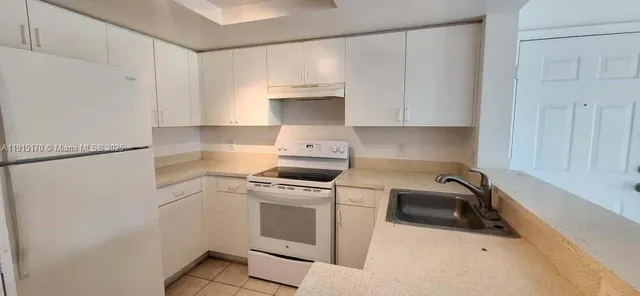 a kitchen with white cabinets and white appliances