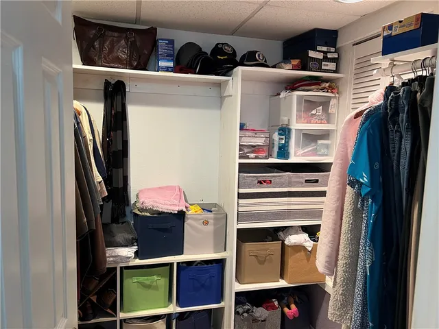 a view of walk in closet with clothes and shoes
