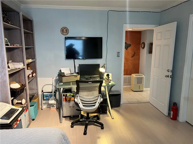 a work room with furniture and a flat screen tv