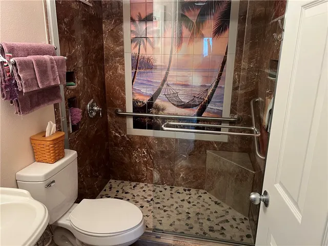 a bathroom with a toilet and a shower