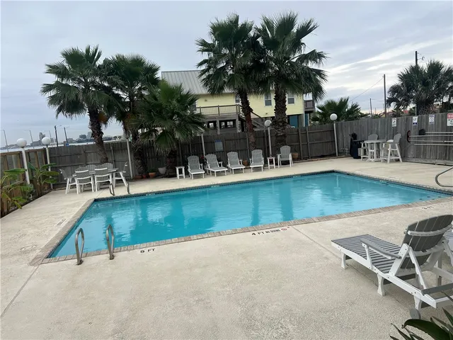 an outdoor space with swimming pool and lounge chair