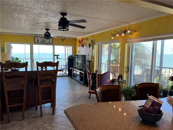 a living room with furniture a flat screen tv and floor to ceiling window