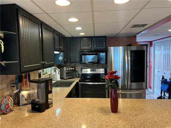 a kitchen with stainless steel appliances kitchen island granite countertop a refrigerator and a stove