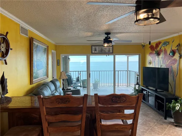 a living room with furniture a flat screen tv and a floor to ceiling window