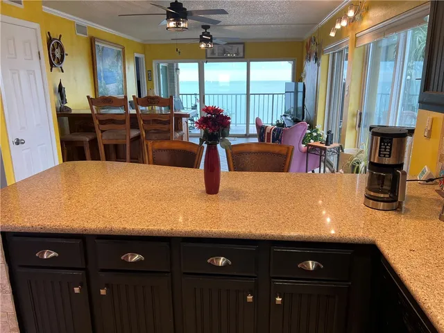 a kitchen with stainless steel appliances granite countertop a sink dishwasher and wooden cabinets with wooden floor