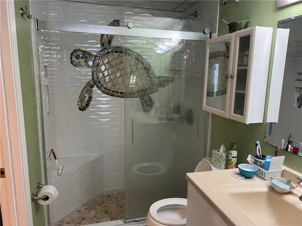 a bathroom with a sink a toilet and shower