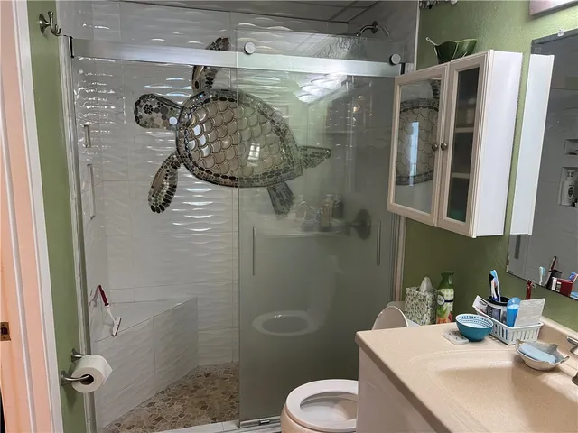 a bathroom with a sink a toilet and shower