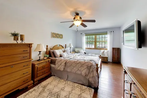 a bedroom with a bed and wooden floor