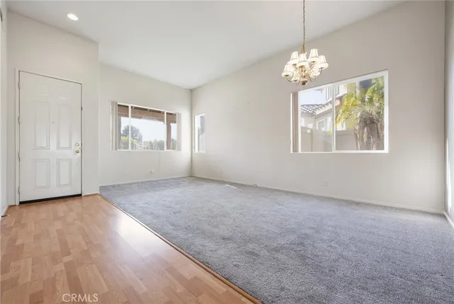 an empty room with windows and chandelier