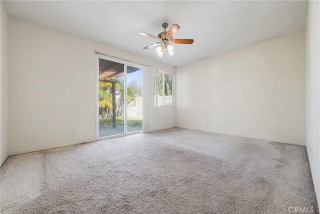 an empty room with closet and a ceiling fan