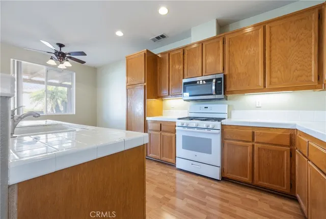 a kitchen with stainless steel appliances granite countertop a stove refrigerator sink and dishwasher with wooden floor